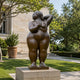 Life-Size Contemporary Voluptuous Female Figure Bronze Sculpture, 200cm, nude form with arms raised behind head, displayed on a stone plinth in a garden setting.