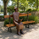 Life-Size Modern Seated Reader Bronze Sculpture, 170cm, hat-wearing figure on a park bench with a bird on its hand and a book in its lap, outdoor garden setting.
