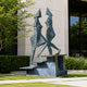 Monumental Modern Abstract Duo Bronze Sculpture, 260cm, two angular cone-headed figures walking on a stepped bronze base outside a modern building.
