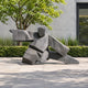 Monumental Abstract Martial Arts Figure Bronze Sculpture, 280cm, dark faceted finish with wing-like arm extensions, shown outdoors on a paved courtyard near greenery.