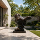 Large Contemporary Volumetric Bird Bronze Sculpture, 200cm, dark cast bronze finish on a plinth in a courtyard patio near a pool and trees.