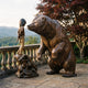 Life-Size Contemporary Rearing Bear and Girl Bronze Sculpture by Giant Sculptures on a stone terrace balustrade with mountain views and a Japanese maple.