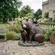 Large Traditional Mother Bear and Cubs Bronze Sculpture by Giant Sculptures on a garden patio, one cub nuzzling her muzzle and another draped across her back.