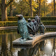 Contemporary Life-Size Penguin Group Bronze Sculpture by Giant Sculptures, five penguins with green verdigris patina on a curved stone ledge above a garden pond.