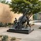 Monumental Contemporary Children with Double Bass Bronze Sculpture by Giant Sculptures, 220cm dark patina cast displayed in a courtyard beside a reflecting pool.