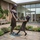 Life-Size Contemporary Children Bronze Statue by Giant Sculptures showing two girls holding hands and leaning back mid-spin, displayed in a courtyard garden.