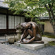 Giant Sculptures Contemporary Seated Nude Female Figure Bronze Sculpture 140cm in folded pose with warm reddish-brown patina, displayed in a Japanese garden.