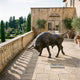 Life-Size Traditional Charging Bull Bronze Sculpture 220cm by Giant Sculptures, shown mid-charge on a villa terrace beside a balustrade overlooking topiary gardens.