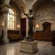 Monumental Classical Lady Justice Bronze Sculpture by Giant Sculptures, blindfolded with scales raised and sword lowered, displayed on a pedestal in a courtroom.
