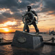 Monumental Traditional Sea Captain Bronze Sculpture by Giant Sculptures on a granite plinth at a waterfront, silhouetted against a sunset sky with harbour cranes.