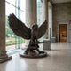Large Traditional Spread-Wing Owl Bronze Sculpture by Giant Sculptures, 150cm, perched on a branch with dark patina finish, displayed in a columned museum hall.