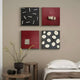 The room showcases a wabi-sabi aesthetic with the Modulus Black & Red Quad Panel Set Abstract Wall Art by Giant Sculptures. It features a minimalist design of four square pieces in black and red, paired with a white bed, wooden side table, and black vase of tall plants, echoing Japanese inspiration.