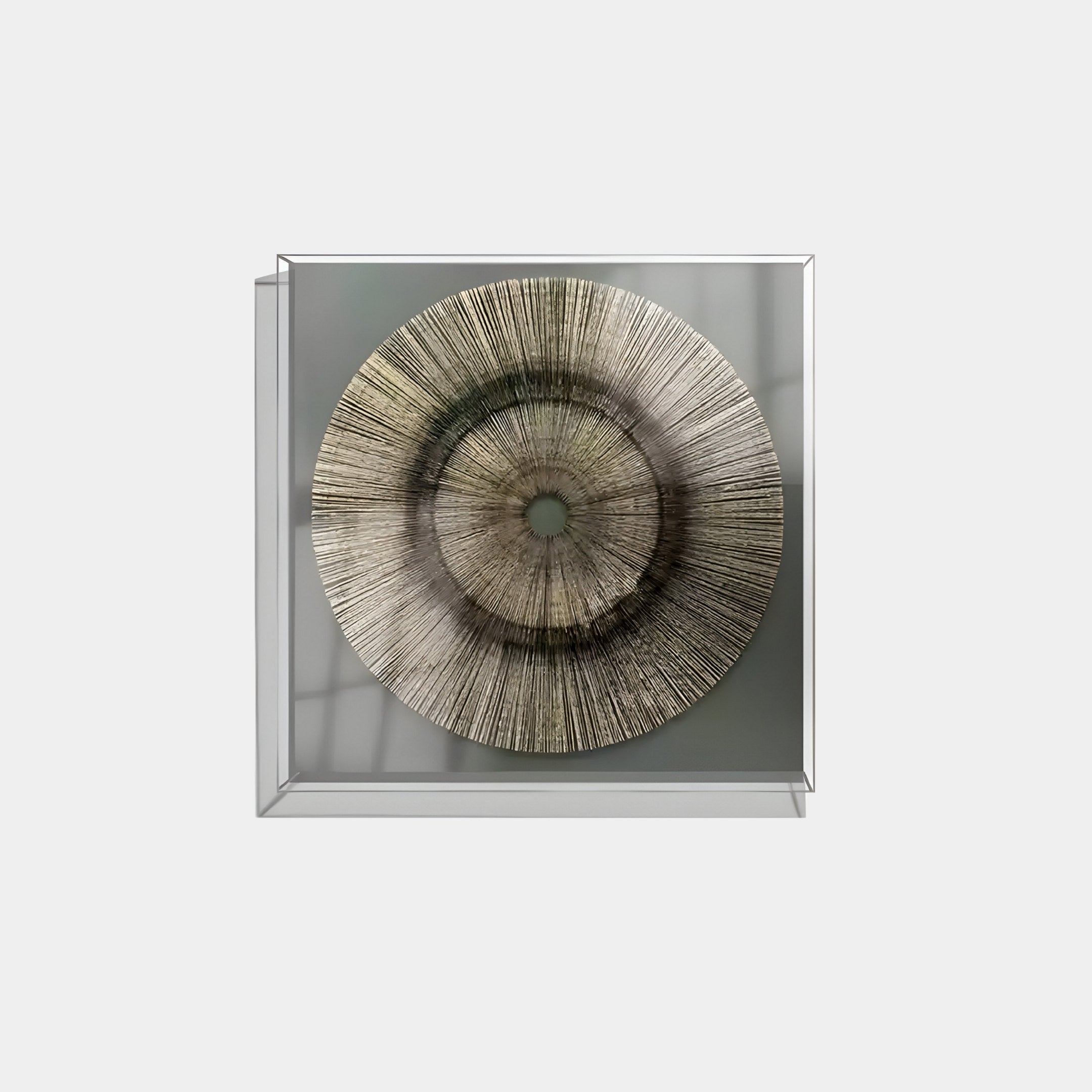 The Oculis Earthy Balance Square Handmade 3D Paper Wall Art by Giant Sculptures features radial patterns in earthy tones in a circular design, encased in a square glass frame. Natural light casts shadows on the left, hinting at a nearby window.