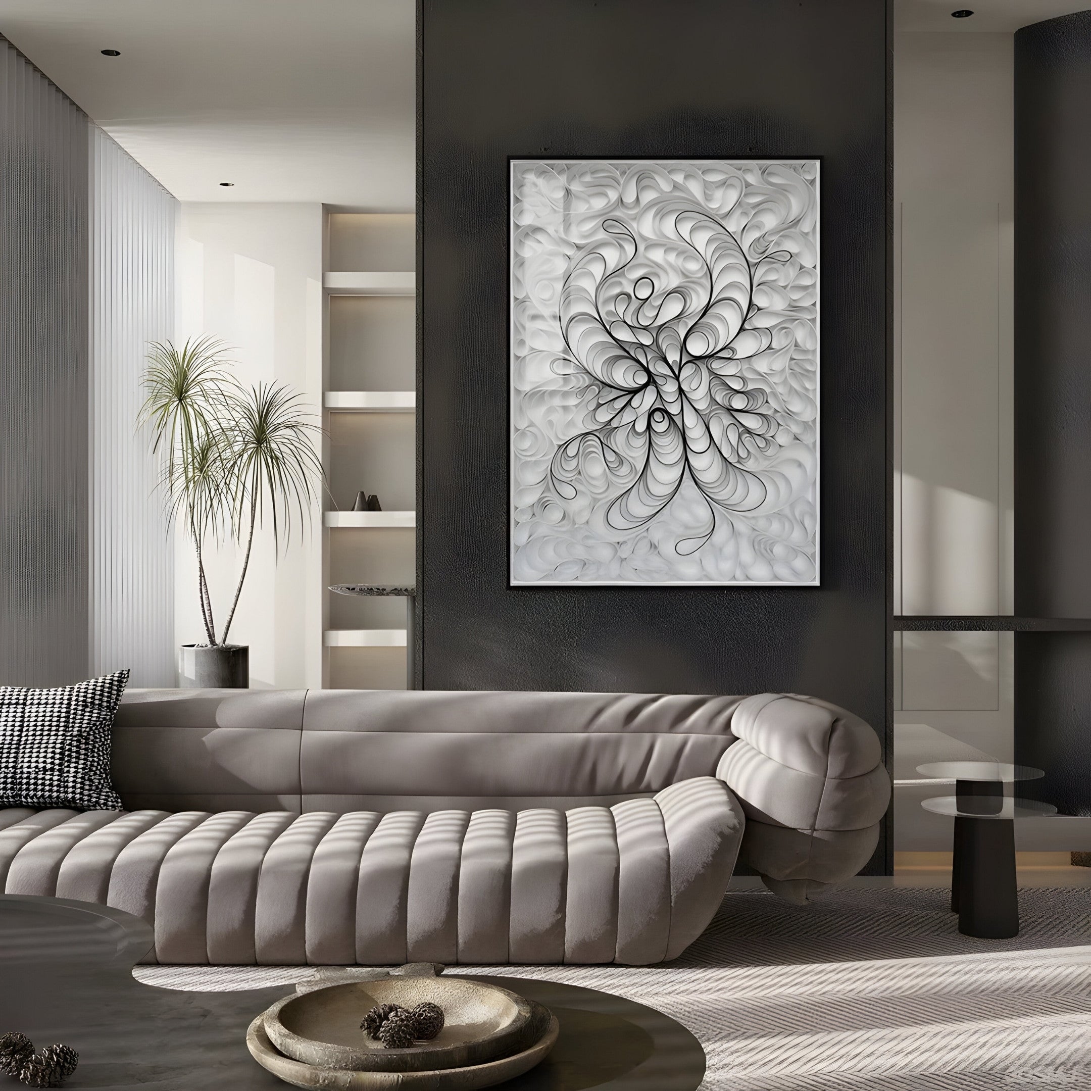 A modern living room with a curvy gray sofa, round coffee table, and the Filigree Monochrome Swirl Quilling Paper Wall Art by Giant Sculptures creating a 3D effect. A tall plant stands by shelves of decorative objects. The neutral palette and minimalistic design foster calmness.