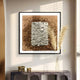 The Terracova Warm Ochre Frame Textured Cardboard Square 3D Wall Art by Giant Sculptures features layered wooden blocks in brown and white. It stands out against a light-colored wall, paired with a modern console adorned with dried grass and sculptures, creating a stunning sunlit effect.