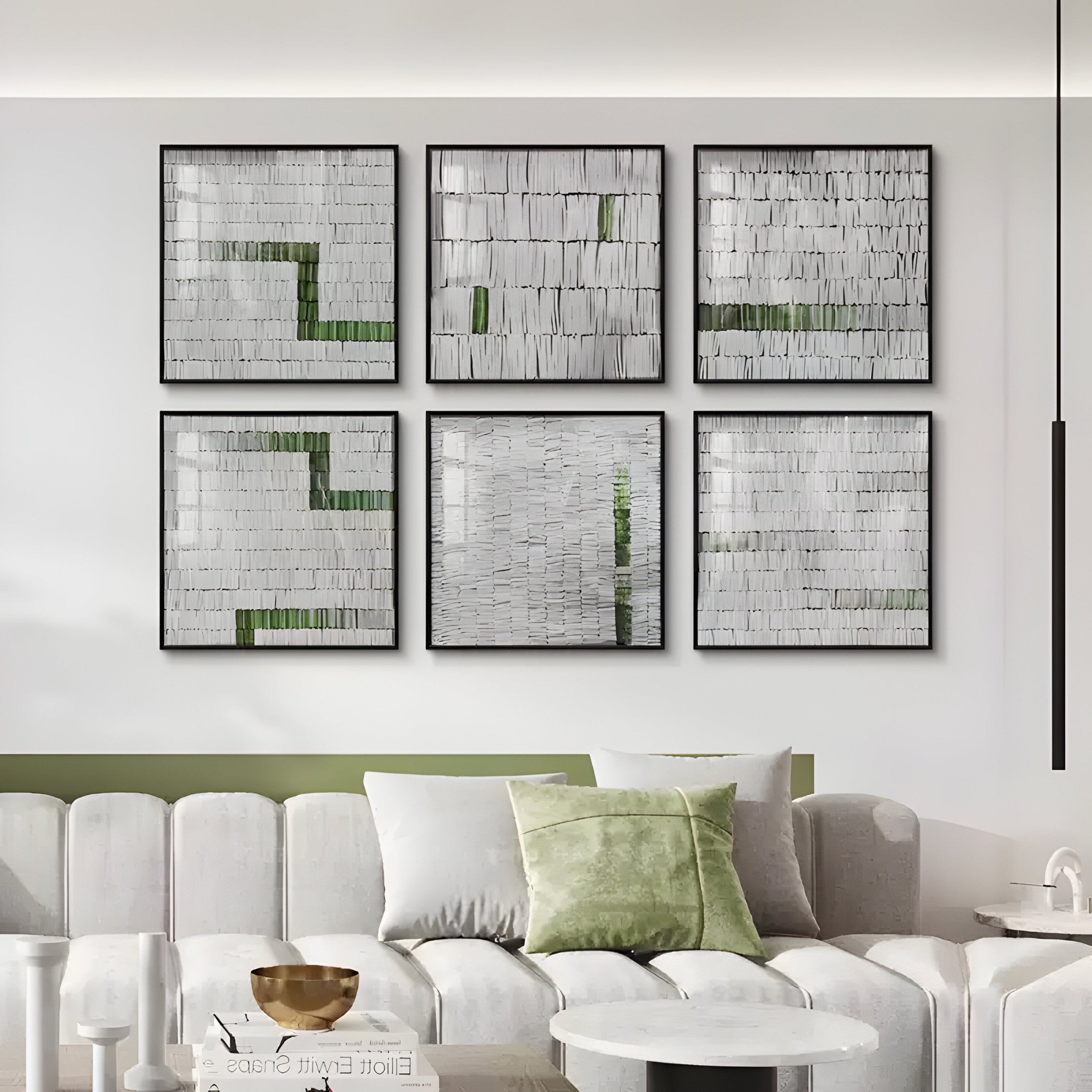 A modern living room features a white couch with light green and gray pillows. Above it, Tracery II Green & White textured wall art by Giant Sculptures, composed of six abstract pieces, hangs elegantly in white, black, and green tones. A wooden bowl adds sophistication to the white coffee table.