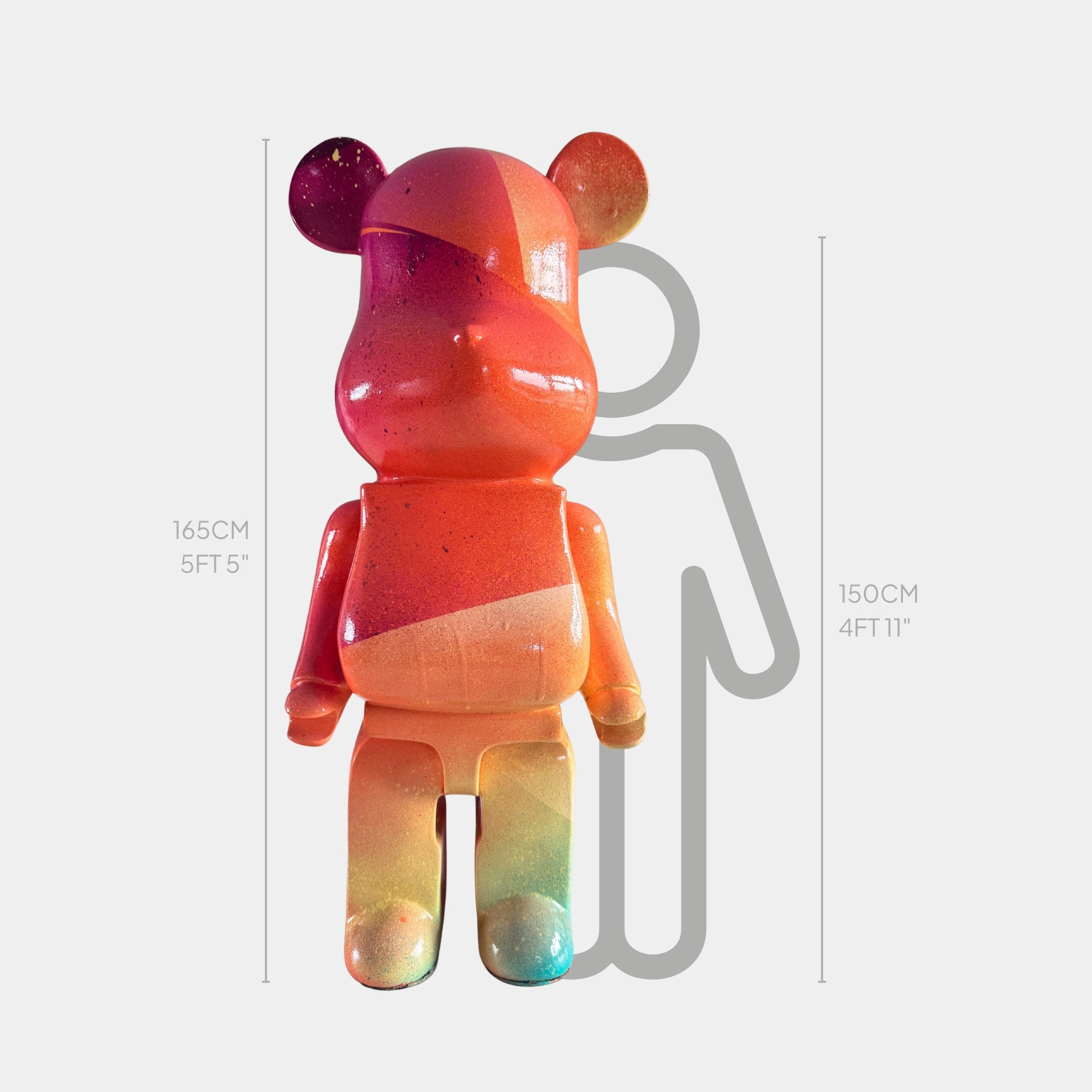 The Candy Bear Sculpture - 165cm by Giant Sculptures stands before a 150 cm tall gray figure for scale, showcasing the vibrant, contemporary art piece's impressive height and unique design.
