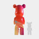 The Candy Bear Sculpture - 165cm by Giant Sculptures features a vibrant red, pink, orange, and yellow gradient. Shown from the back with a smaller semi-transparent gray version to the right, it stands out against a white background.