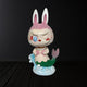 The Carnival Secret Mermaid Labubu Sculpture - 160cm by Giant Sculptures showcases a pink bunny-headed mermaid with expressive eyes and a mischievous grin, crafted from fibreglass with a museum-grade finish, standing on a wave.
