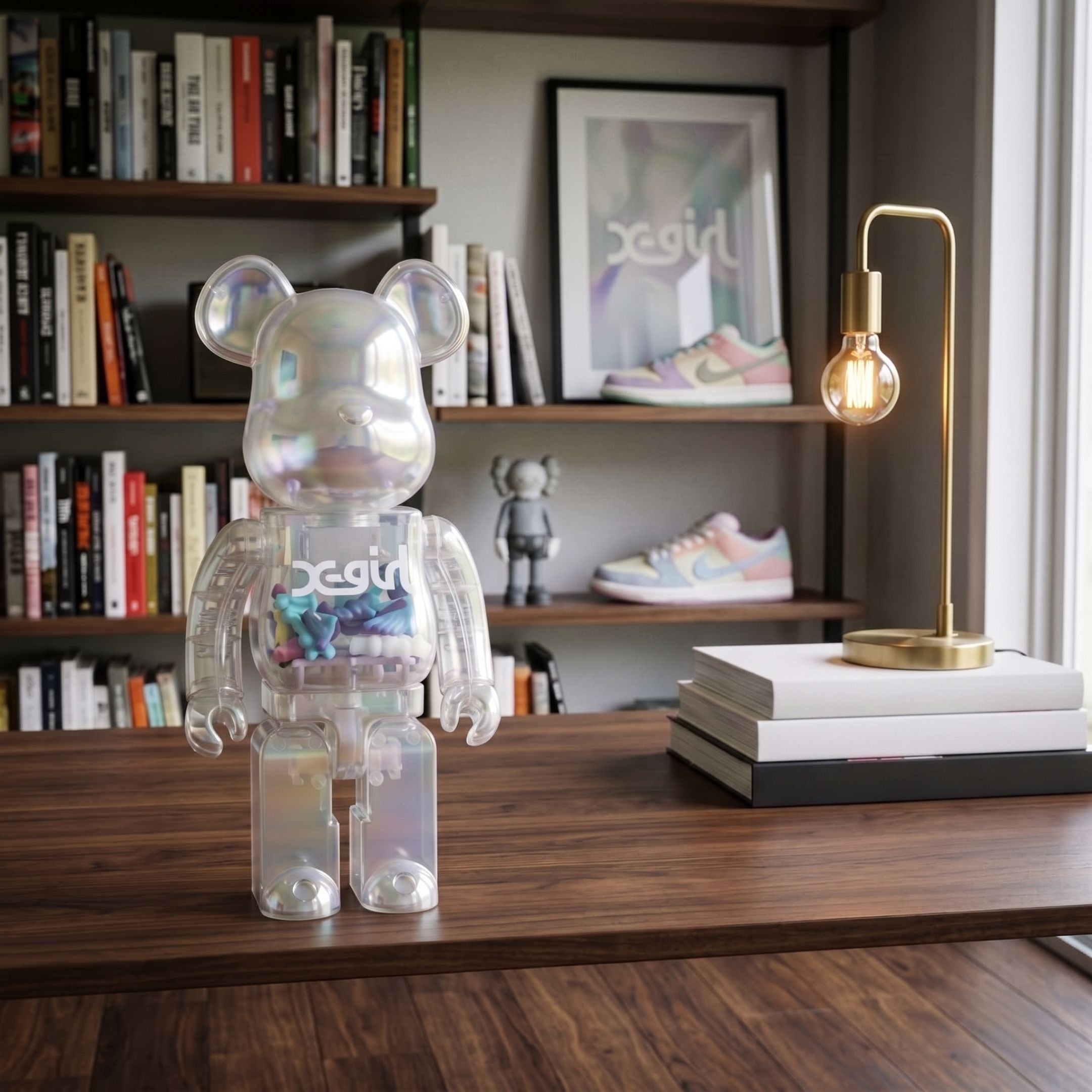 Clear Mirage Bear Sculpture (70cm) by Giant Sculptures, an iridescent transparent bear figure with mini-bears inside, displayed on a wooden desk near a brass lamp and bookshelf.