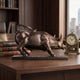 Contemporary Charging Bull Bronze Sculpture by Giant Sculptures displayed on a wooden desk beside stacked stock market books and a brass mantel clock.