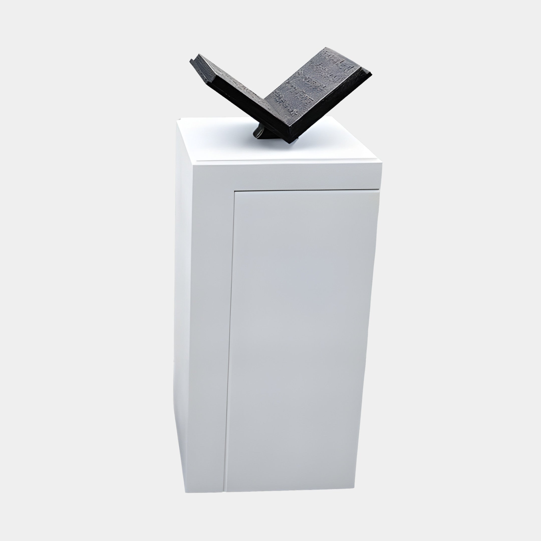 Black Book on White Pedestal Sculpture by Giant Sculptures, featuring a textured open book in black 3D-printed resin atop a tall white plinth against a light background.