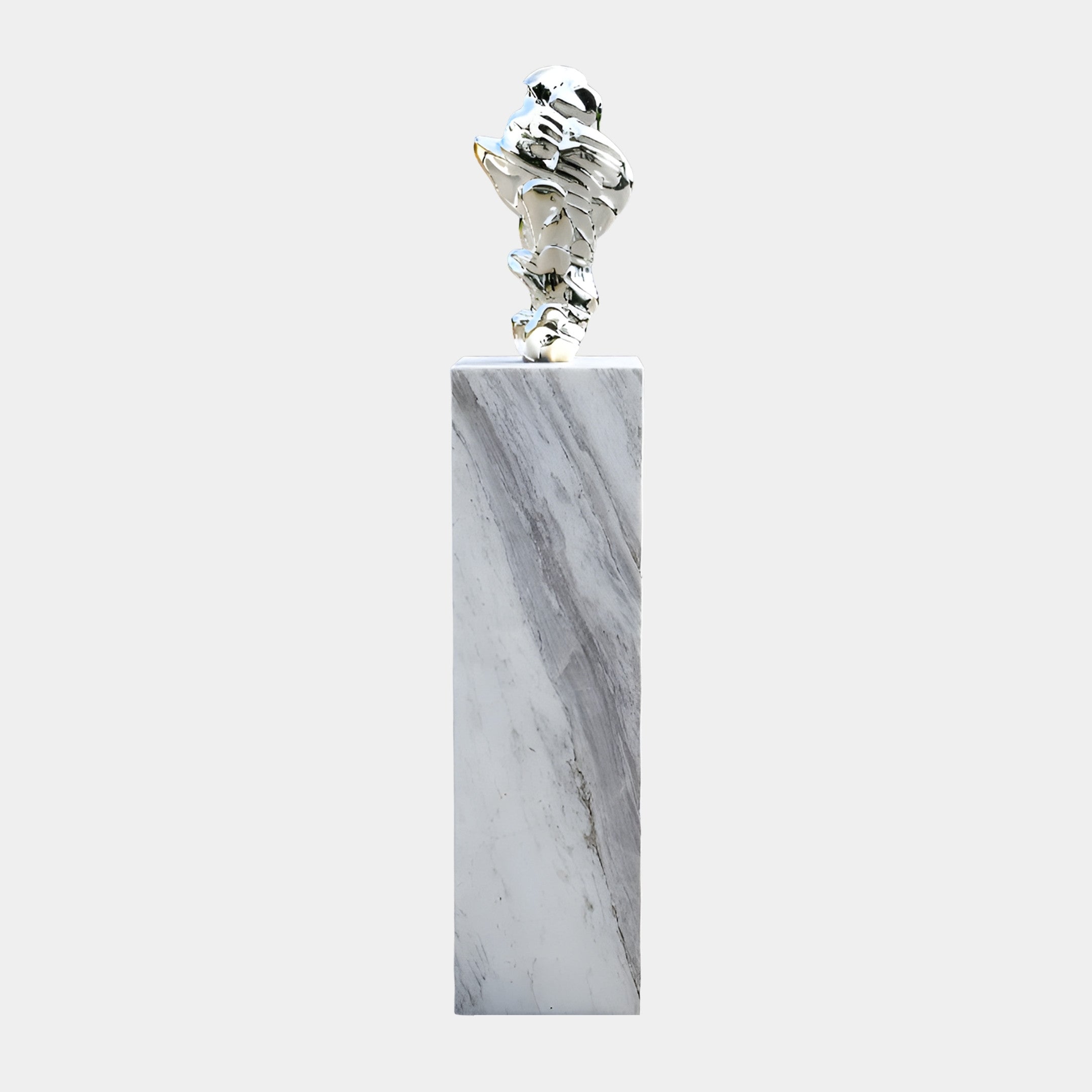 Giant Sculptures Silver Abstract Crumpled Form Sculpture in mirror chrome resin on a tall white marble plinth, shown against a plain light background.
