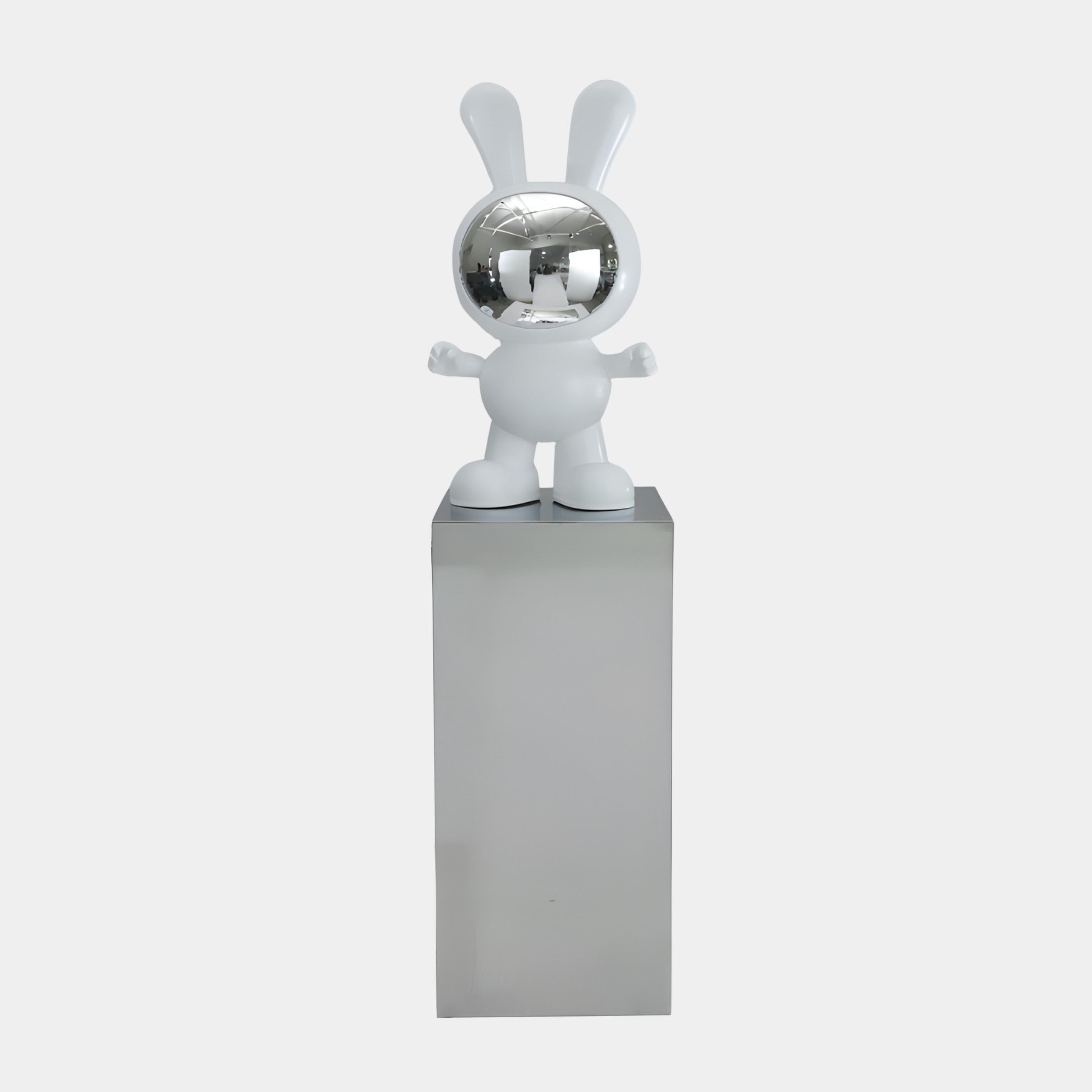White and chrome astronaut rabbit sculpture by Giant Sculptures with glossy white suit, long ears, and mirrored visor, displayed on a tall mirror-steel plinth.