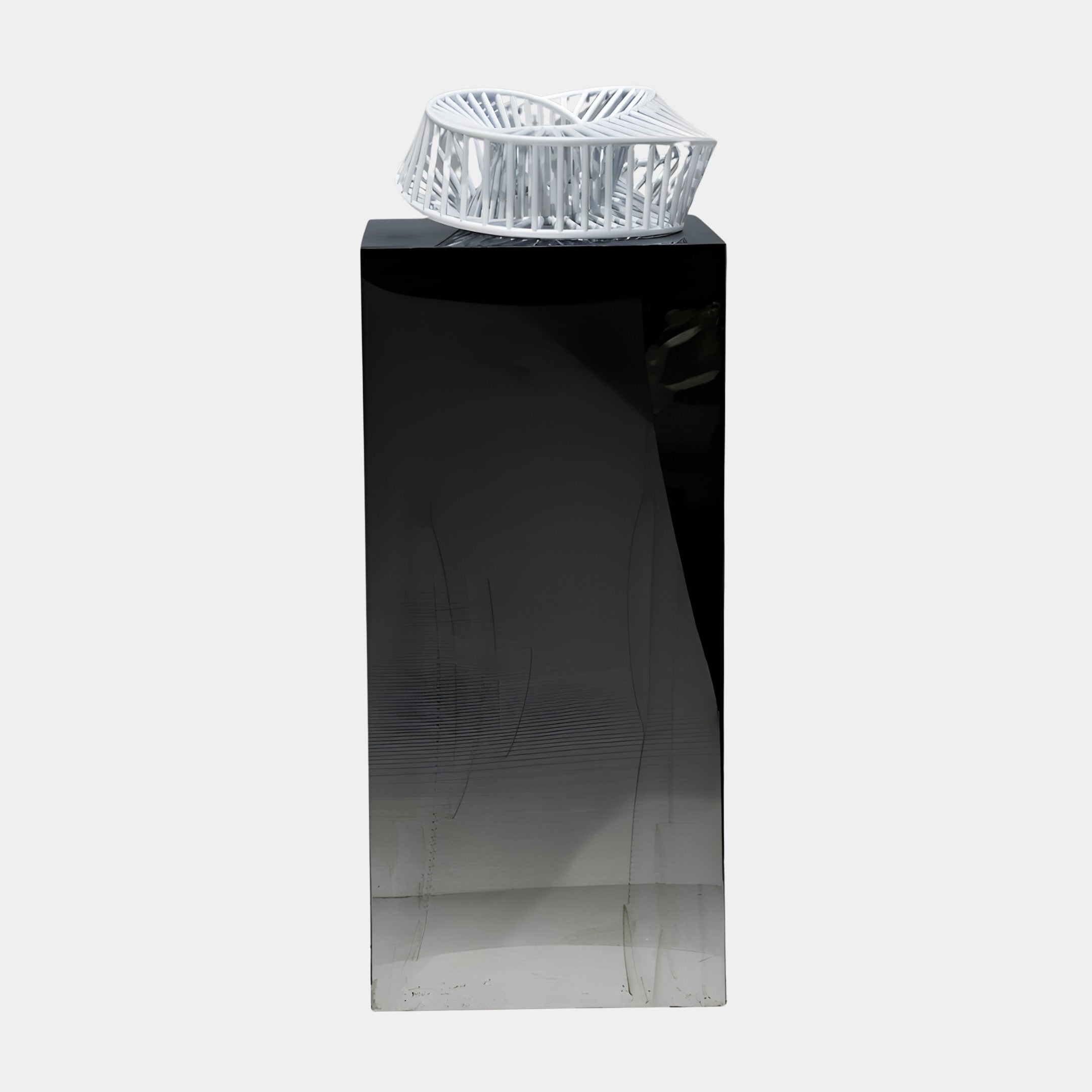 White Wire Abstract Nest Bowl by Giant Sculptures, a 3D-printed open lattice ring in white resin displayed on a tall glossy black plinth against a plain background.