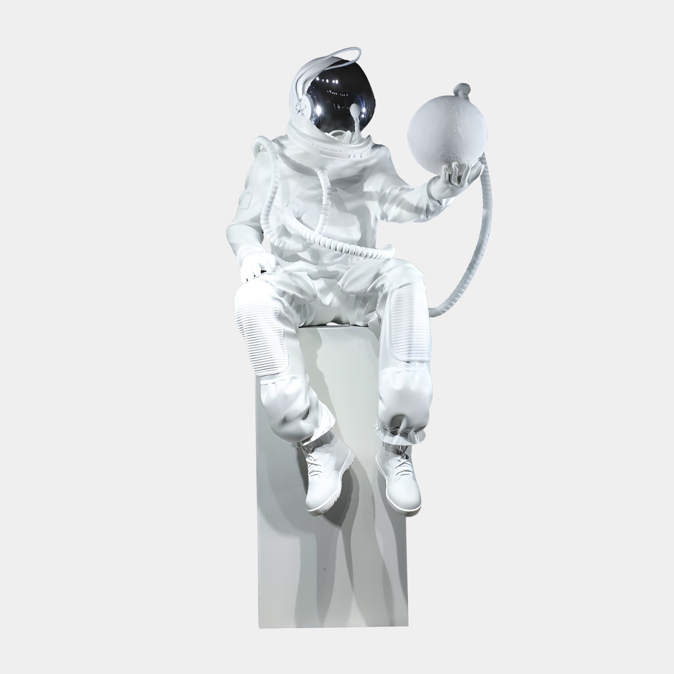 Giant Sculptures White Astronaut with Equipment Sculpture 90cm, seated on a white plinth in glossy resin with chrome visor, cradling a textured moon orb.