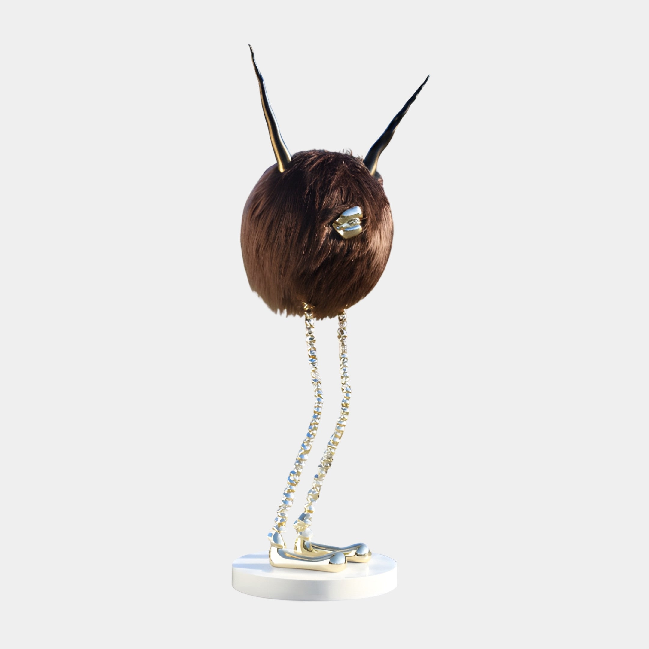 Brown Furry Abstract Creature Sculpture by Giant Sculptures with a flocked round body, black-and-gold antennae, jewelled eye, and beaded metallic legs on a white base.