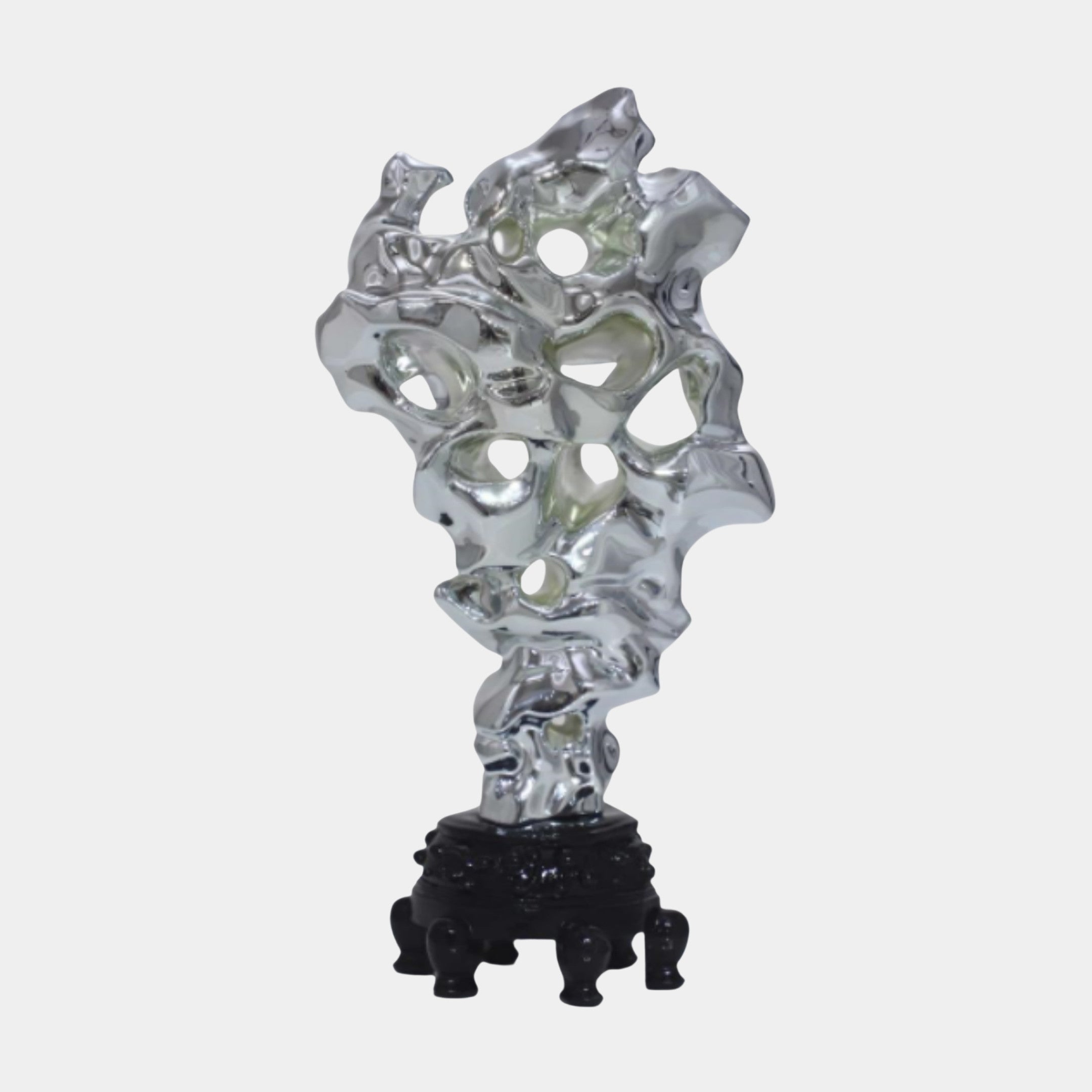 Silver Abstract Crumpled Forms Sculpture 30cm by Giant Sculptures, a chrome-finished perforated scholar's rock on a carved black wood stand, plain background.
