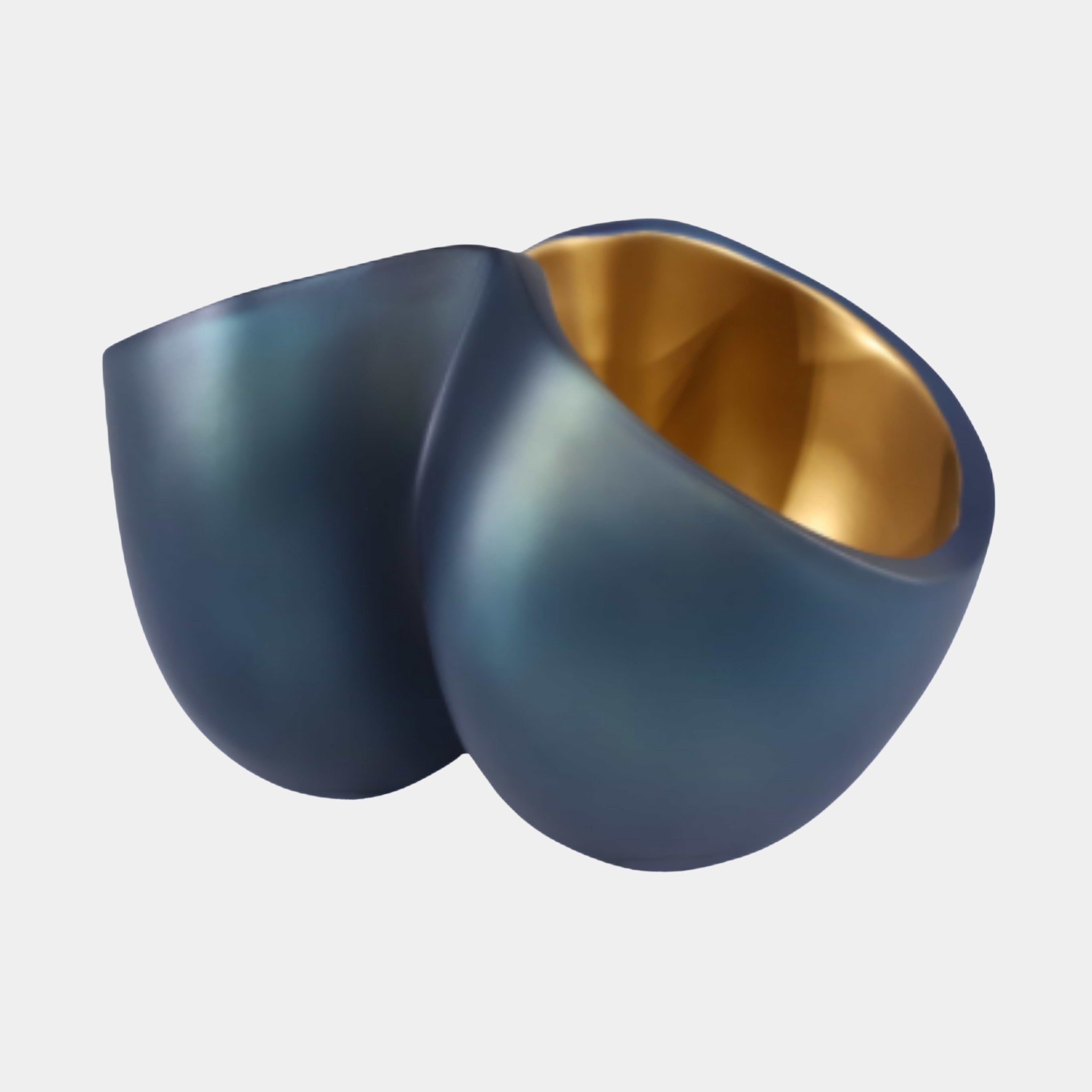 Black and Gold Abstract Split Bowl by Giant Sculptures, two overlapping curved shells in matte navy-black with a polished gold interior, on a plain background.
