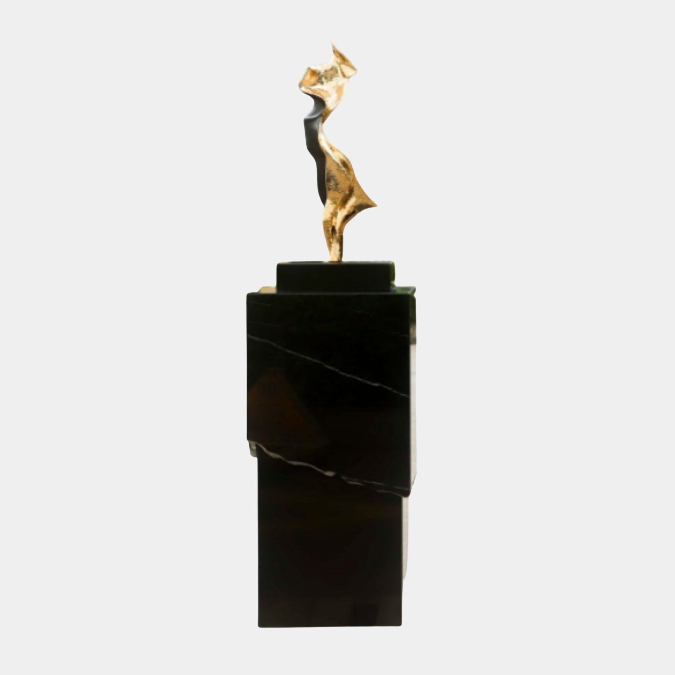 Giant Sculptures Gold Abstract Walking Figure with a dark accent sweep, displayed on a tall tiered black marble plinth against a plain background.