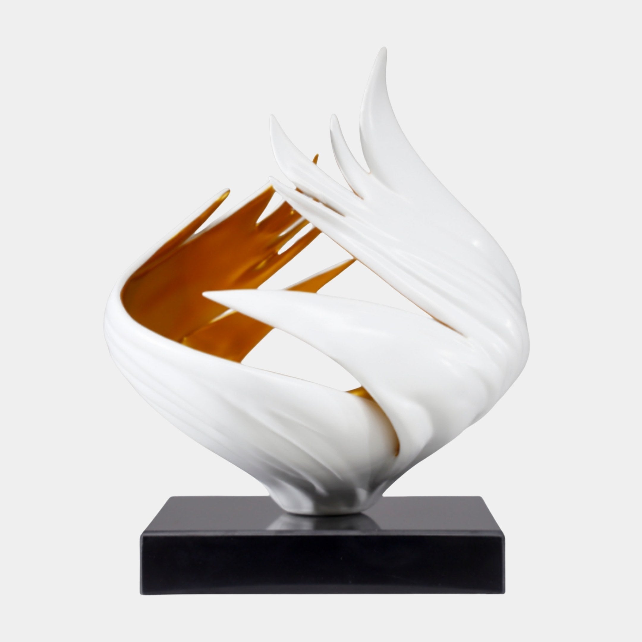 Giant Sculptures' White and Gold Abstract Flame sculpture with sweeping white petals revealing a gold-lined interior, set on a black marble base against a plain background.