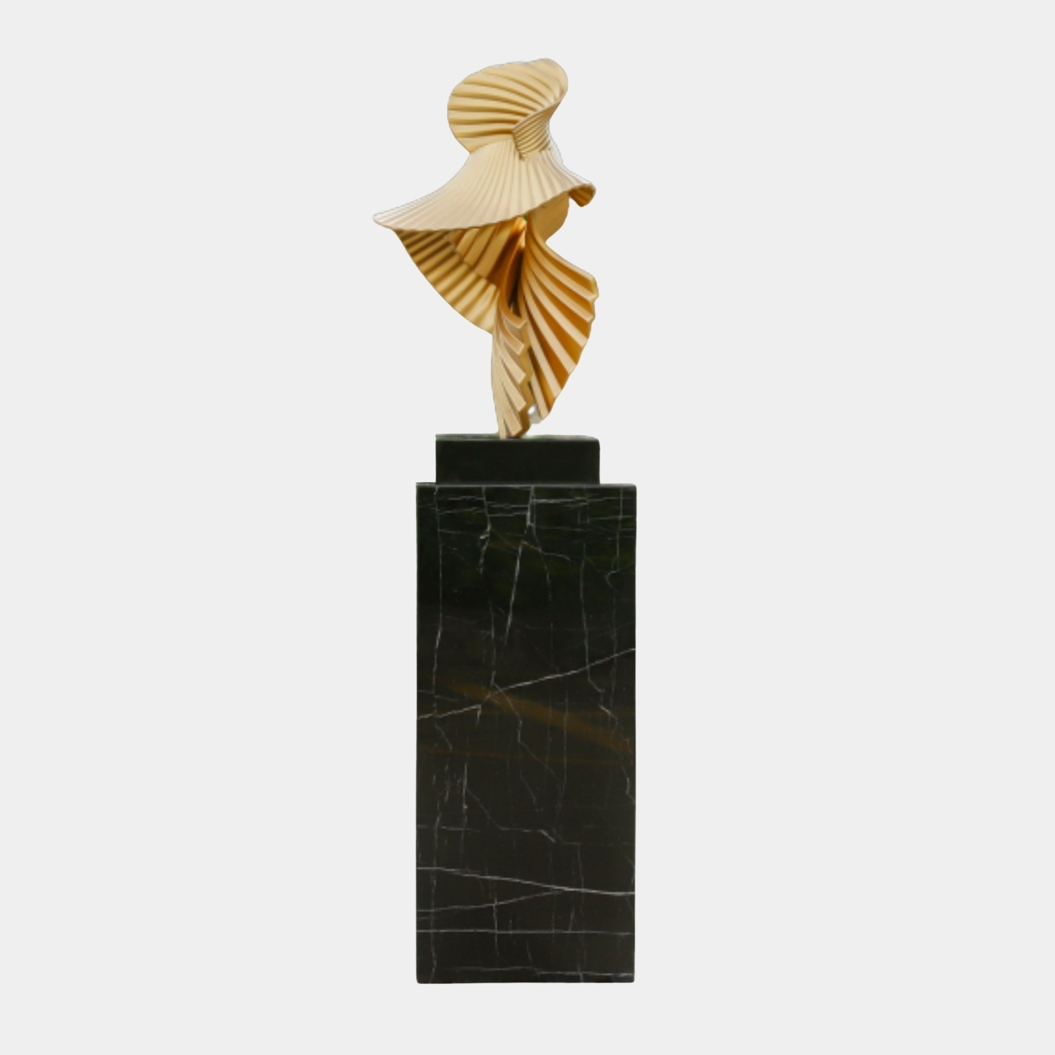 Gold Abstract Fluted Ribbon Sculpture by Giant Sculptures, with pleated fan-like ribbons spiralling upward on a tall black marble pedestal against a plain background.