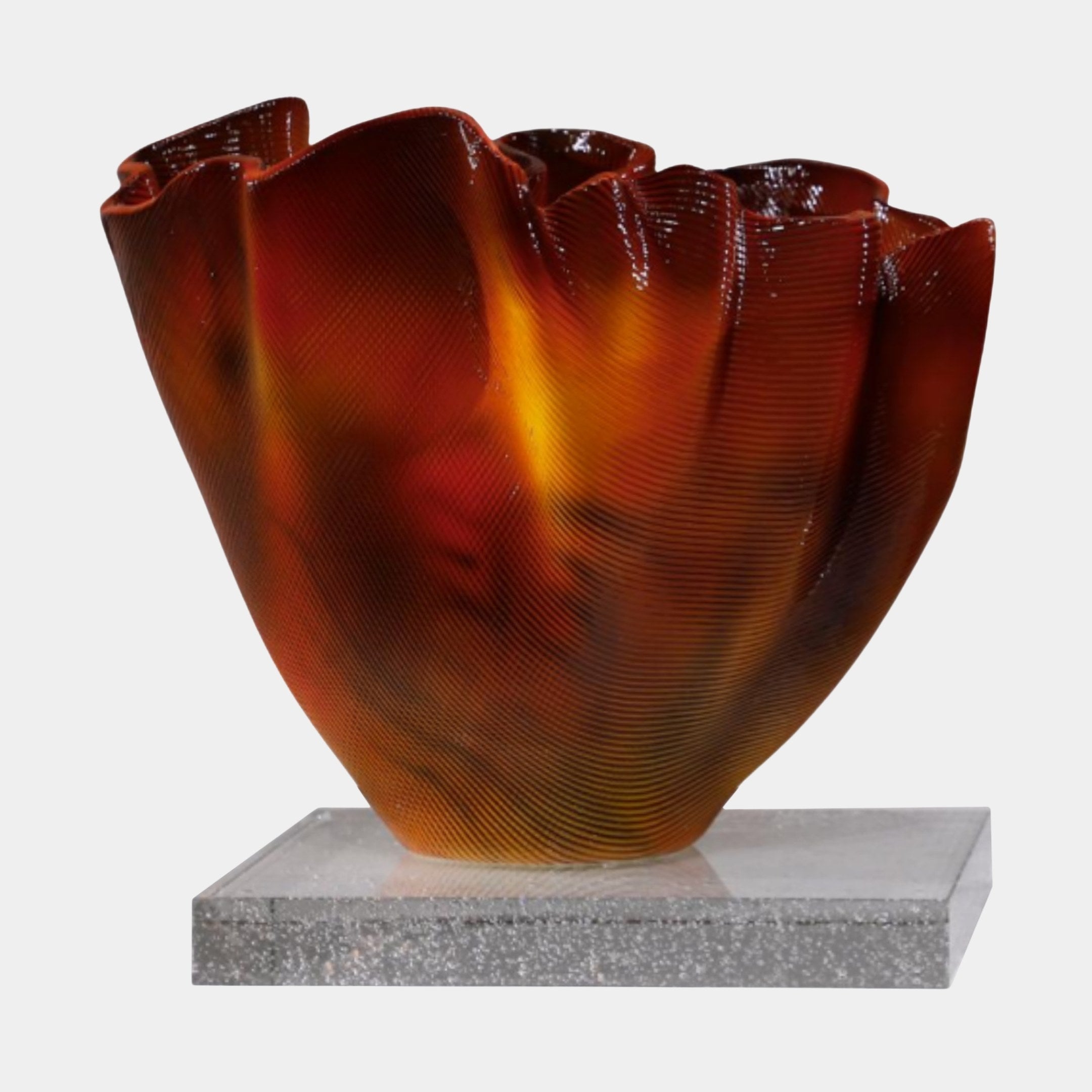 Amber Glass Abstract Flame Bowl by Giant Sculptures, a 3D-printed resin sculpture with ribbed, ruffled walls in glowing red and orange, set on a clear base.