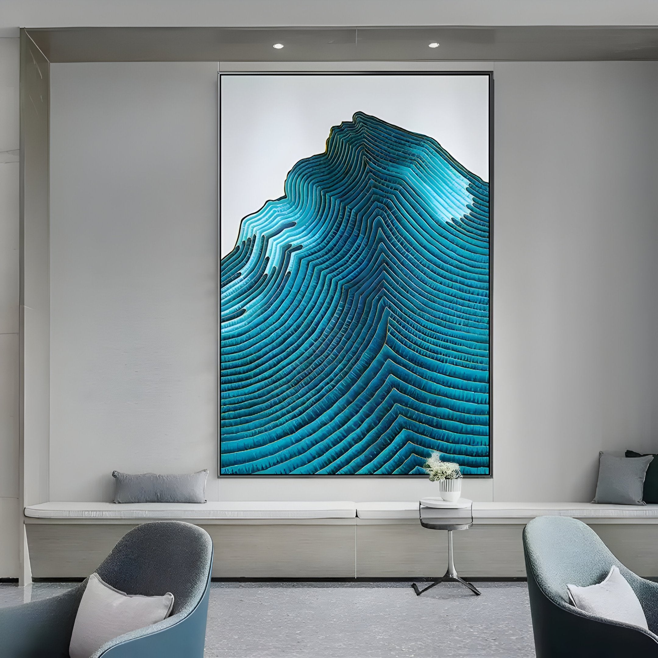 Giant Sculptures Ripplewave I Abstract Blue Decorative Enamel Wall Art adorns a minimalist room wall, displaying blue, wave-like patterns akin to layered contours. The modern interior also features gray seating and a small white side table.