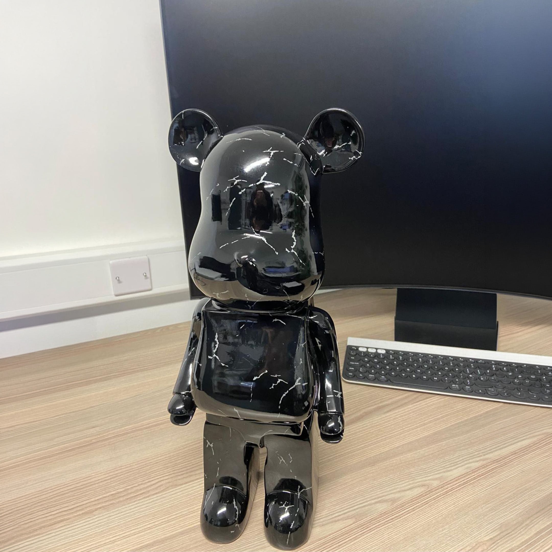 Black Stone Bear Sculpture 50cm by Giant Sculptures with glossy marbled finish, displayed on a wooden desk beside a monitor and keyboard.