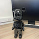 Black Stone Bear Sculpture 50cm by Giant Sculptures with glossy marbled finish, displayed on a wooden desk beside a monitor and keyboard.