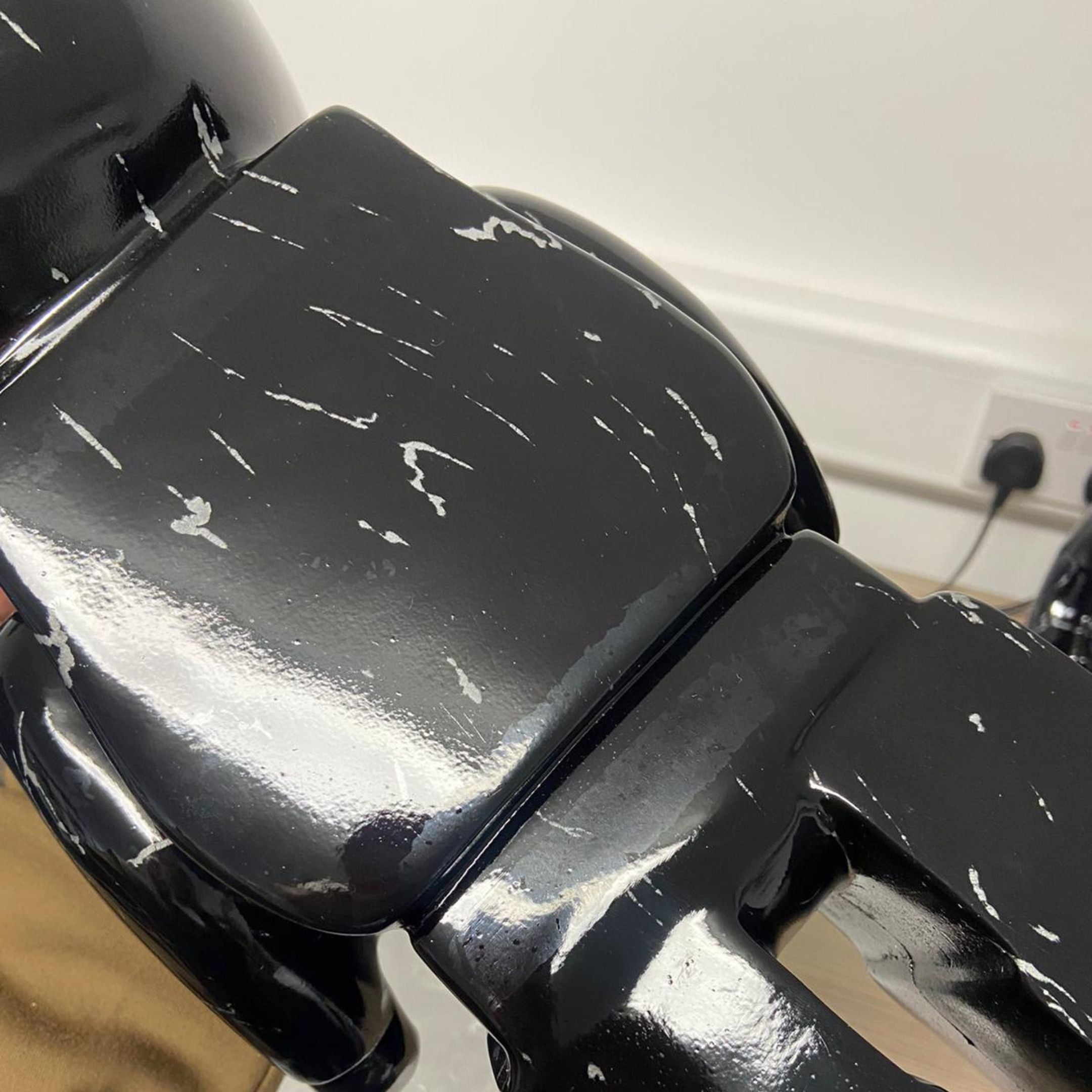 Close-up of the Giant Sculptures Black Stone Bear Sculpture 50cm showing glossy black resin finish with visible scuff marks and paint chips on the shoulders.