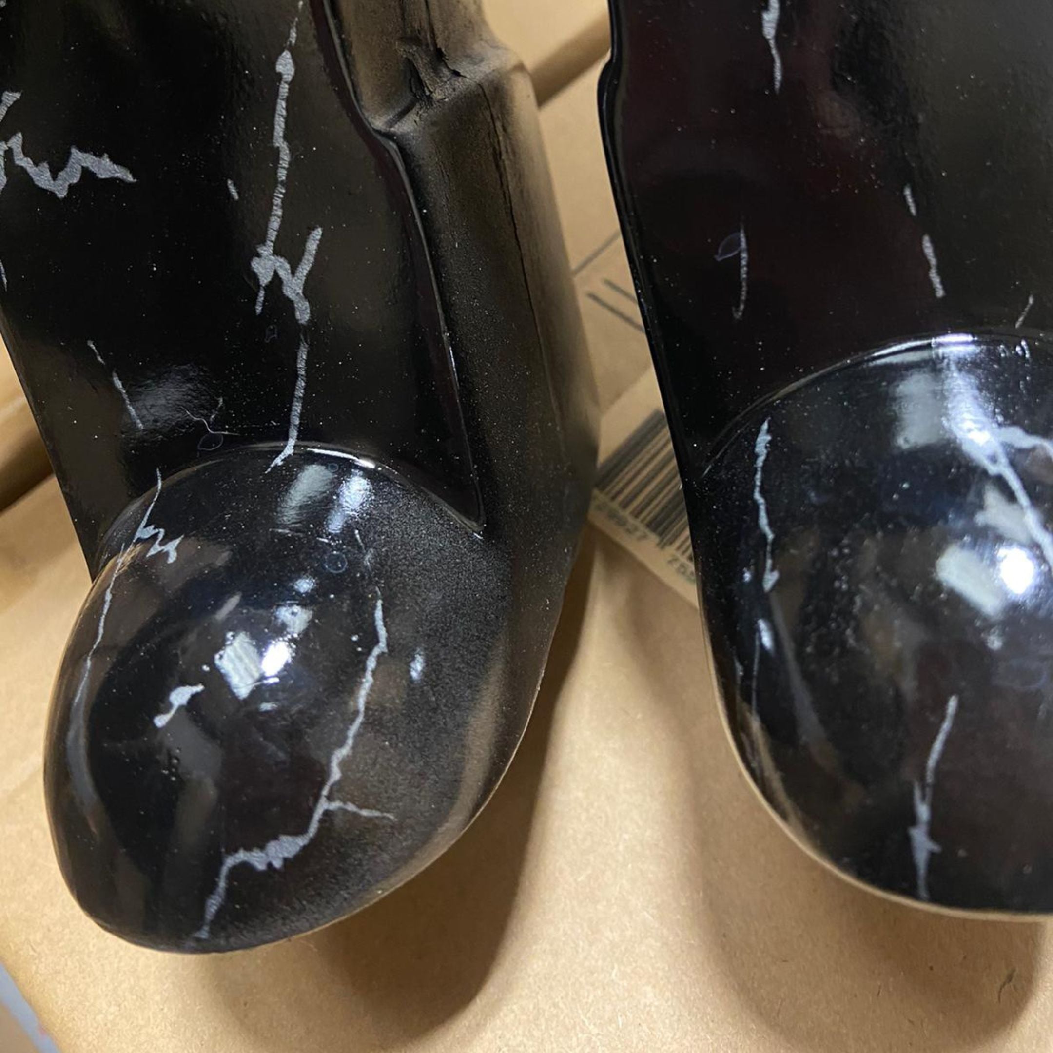 Close-up of the Giant Sculptures Black Stone Bear Sculpture 50cm showing the glossy black resin finish with white veining across the rounded feet.