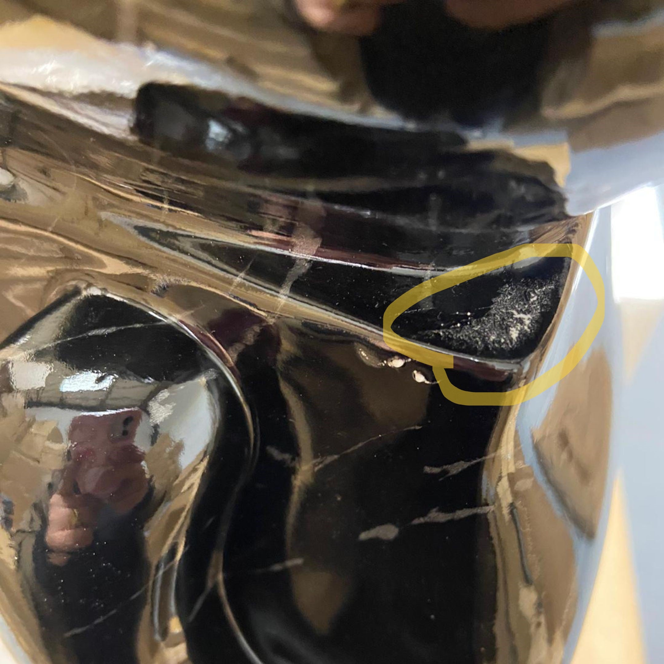 Close-up of the Giant Sculptures Black Stone Bear Sculpture 50cm showing the glossy faceted resin finish with a marked area highlighted on the surface.