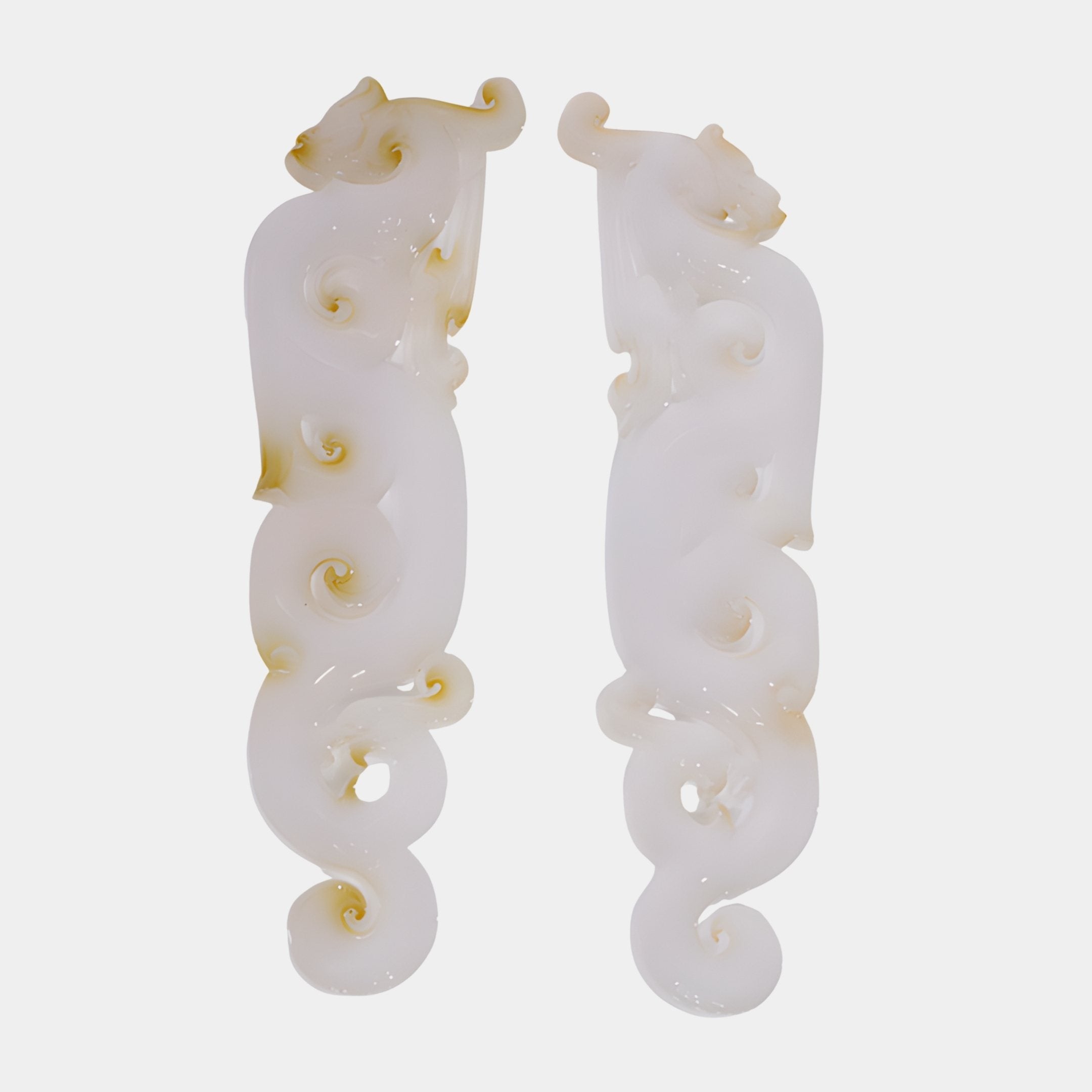 Dragon Scroll White Carved Jade Ornament Set by Giant Sculptures, a mirrored pair of 54cm ivory-white scrolls with dragon heads and curling tails on a plain background.