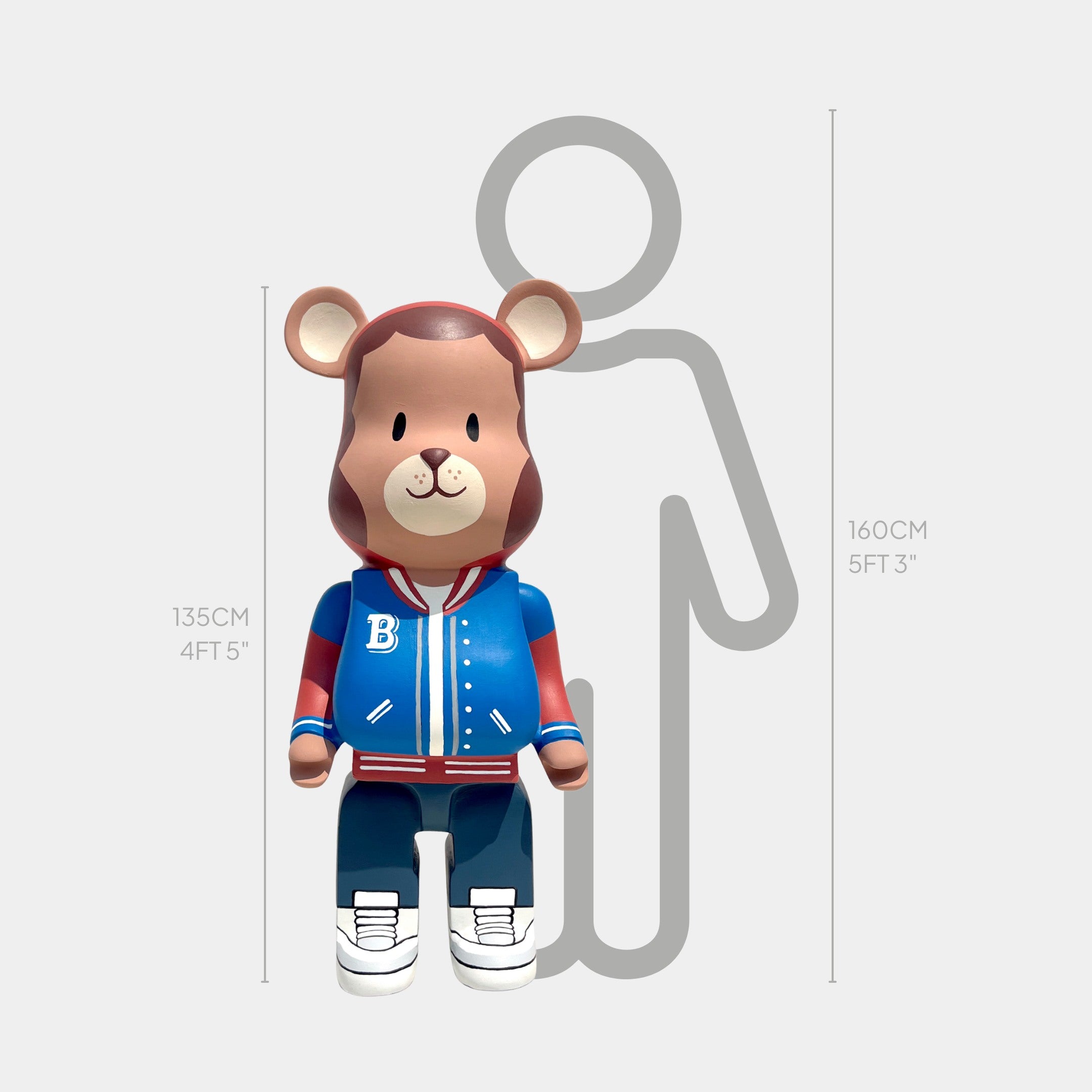 The Fresh Grizz Bear Sculpture - 135cm by Giant Sculptures features a bear in a blue and red varsity jacket, standing at 135 cm beside a gray human outline at 160 cm—a truly unique streetwear-inspired piece.