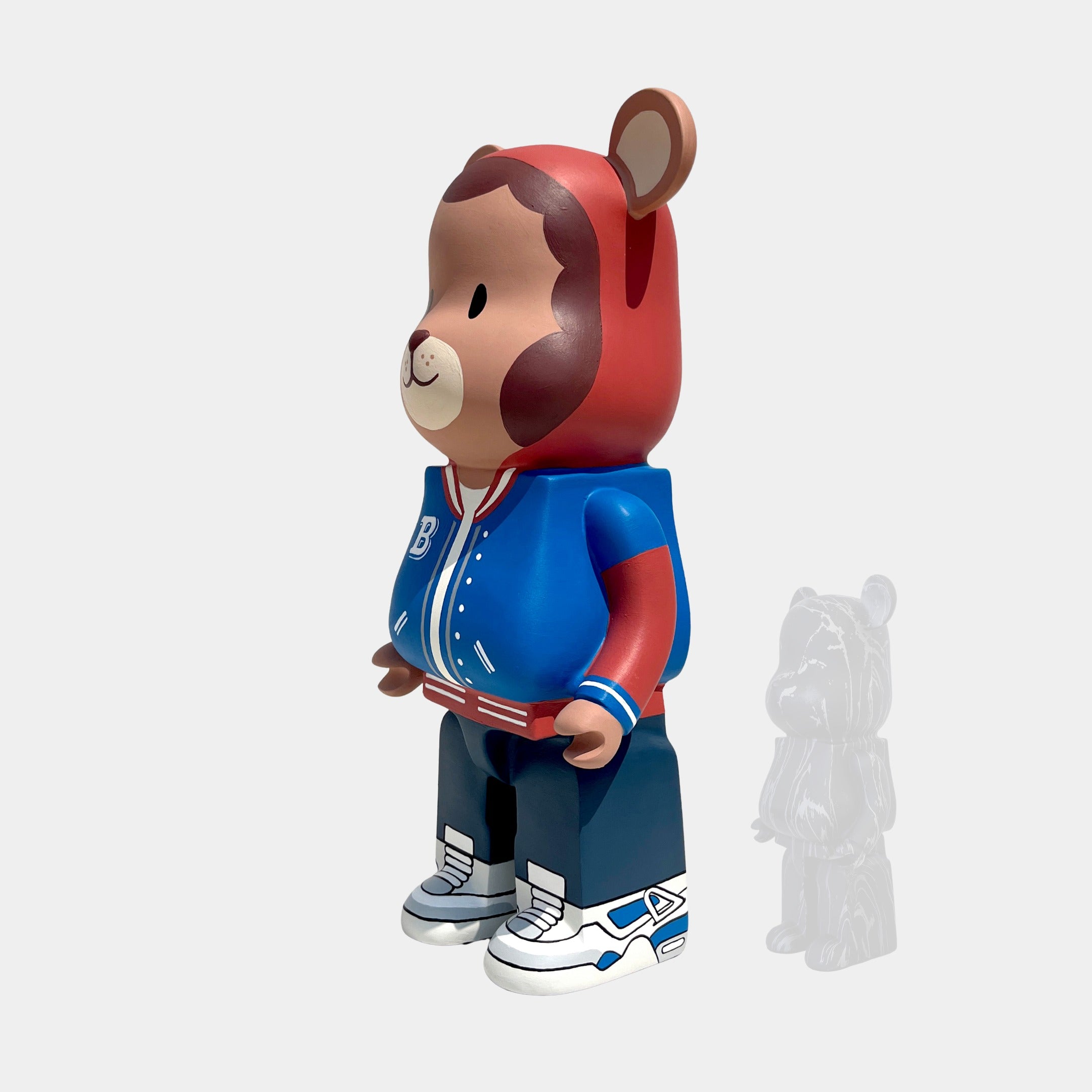 The Giant Sculptures Fresh Grizz Bear Sculpture - 135cm features a streetwear-inspired bear in a red hoodie with bear ears, blue varsity jacket, and sneakers, with a smaller translucent bear figure in the background.