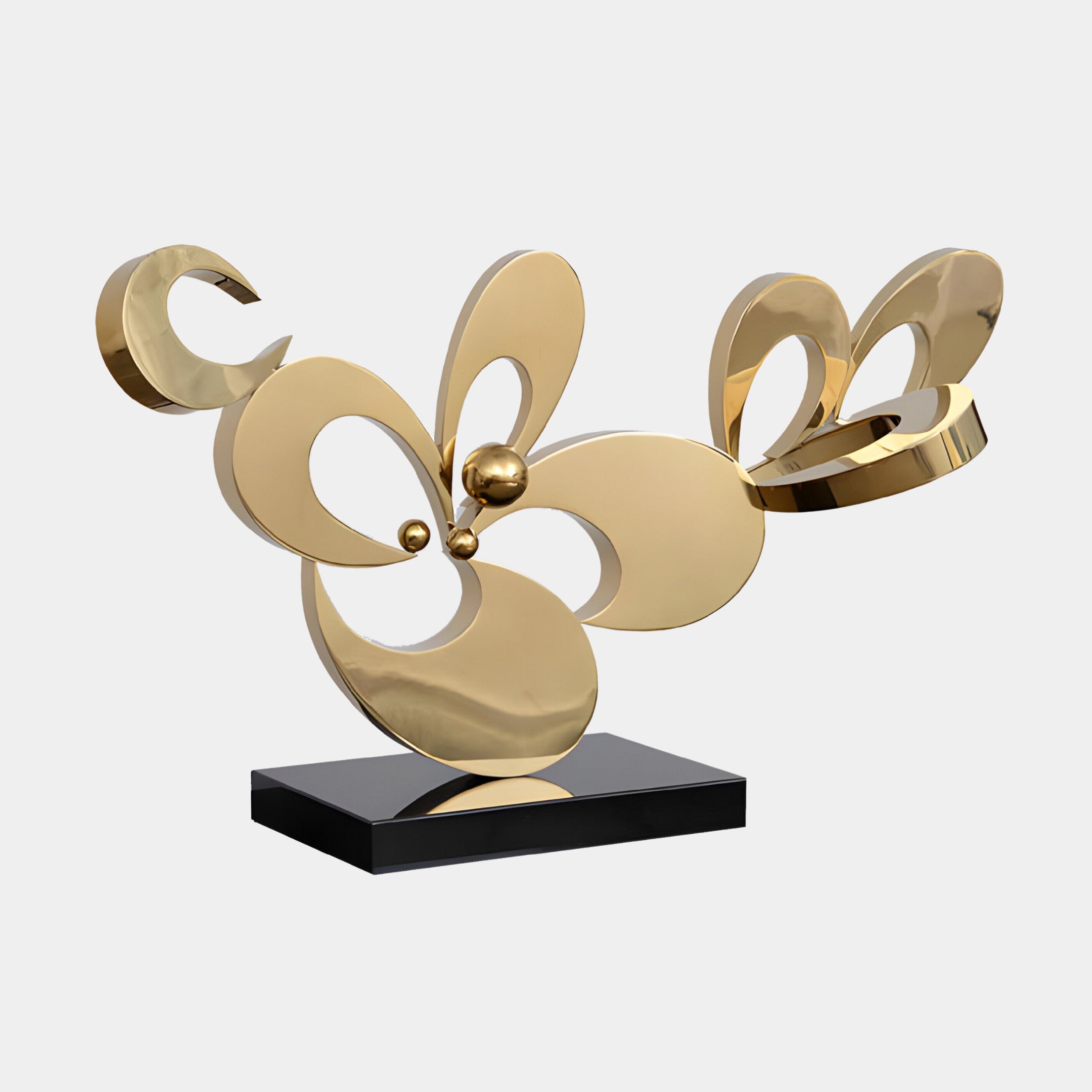 Modern abstract golden floral sculpture with petal-like shapes on a black base.