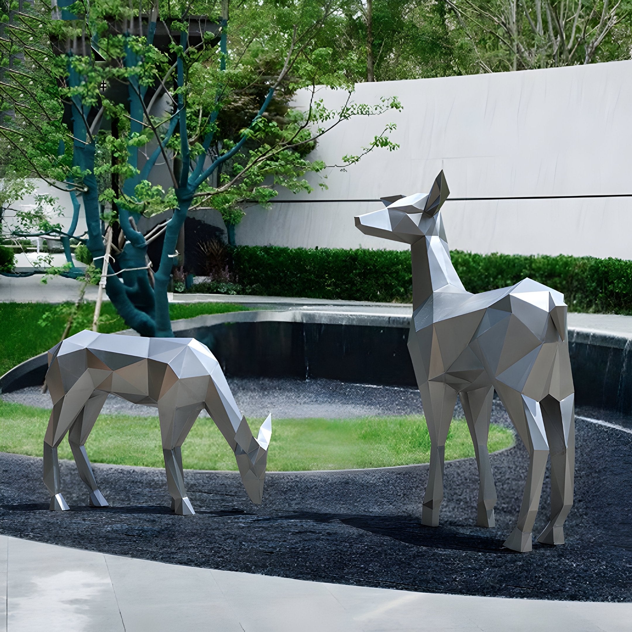 Two stunning Deer III Geometric Steel Outdoor Sculptures by Giant Sculptures grace a greenery-filled courtyard. One deer grazes peacefully while the other stands upright, with a curved stone wall and tree enhancing the tranquil setting.