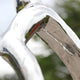 Close-up of the Blossom Tree Contemporary Steel Sculpture by Giant Sculptures shows its shiny stainless steel surface with distorted reflections of trees and buildings. The smooth, curved lines highlight the modern artistry of this 180/245cm piece.