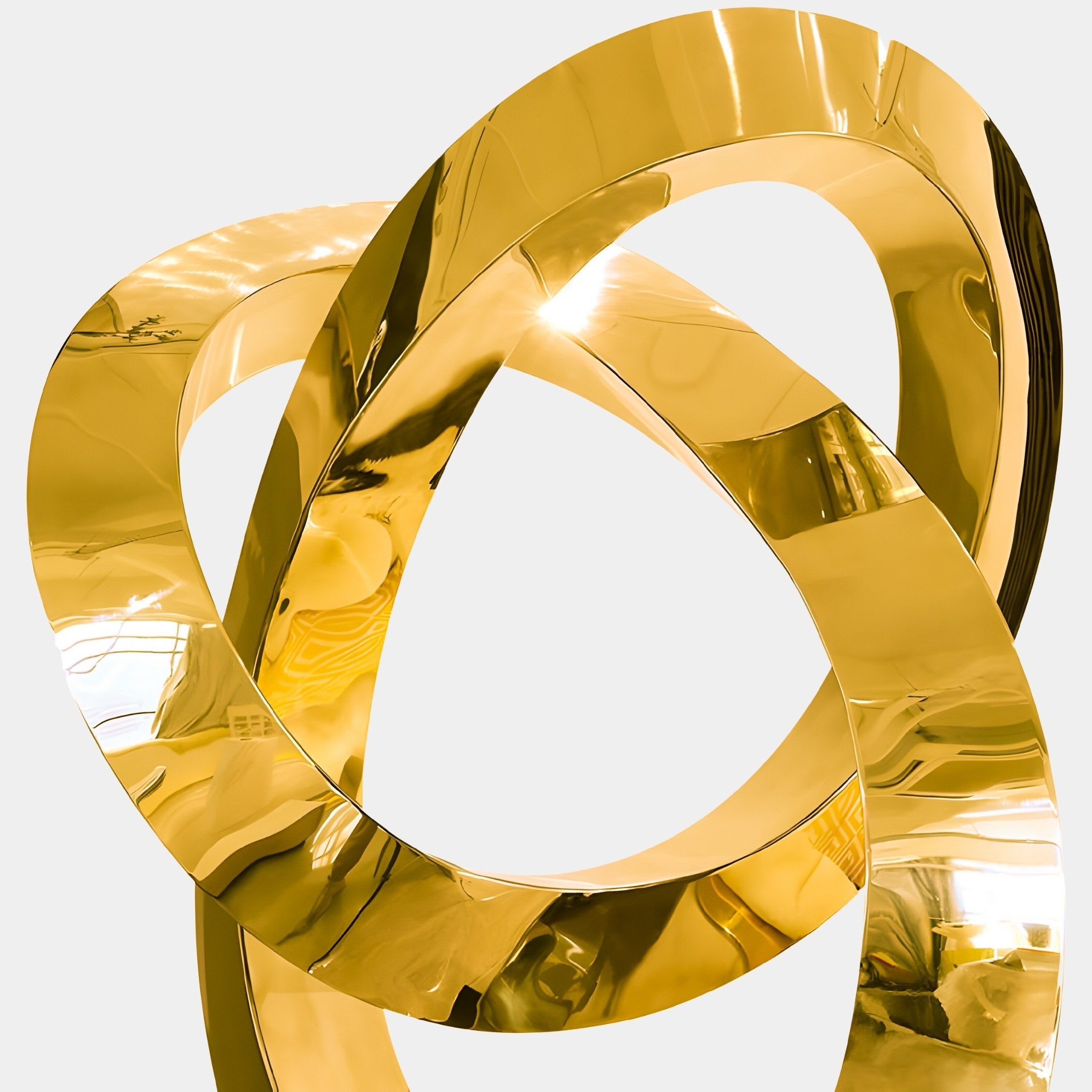 This Boundless Gold Abstract Steel Sculpture by Giant Sculptures is a shiny, modern art piece with intertwined gold loops that reflect light beautifully, measuring 88cm and offering a dynamic, elegant look against a plain background.